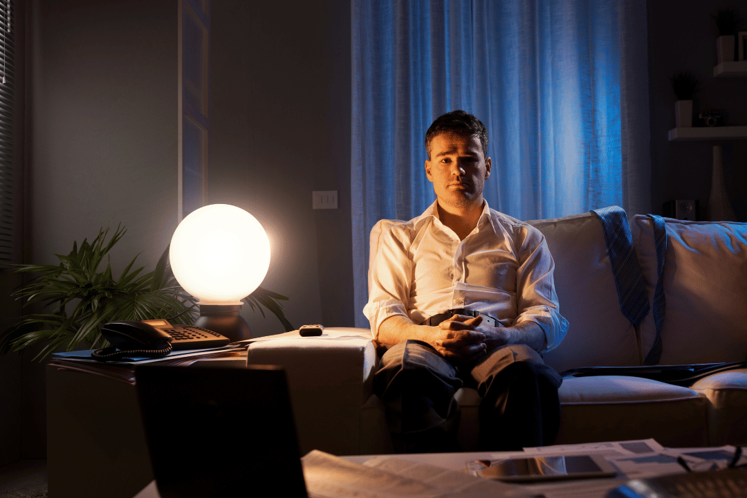 A man sitting in a loneliness room during nighttime